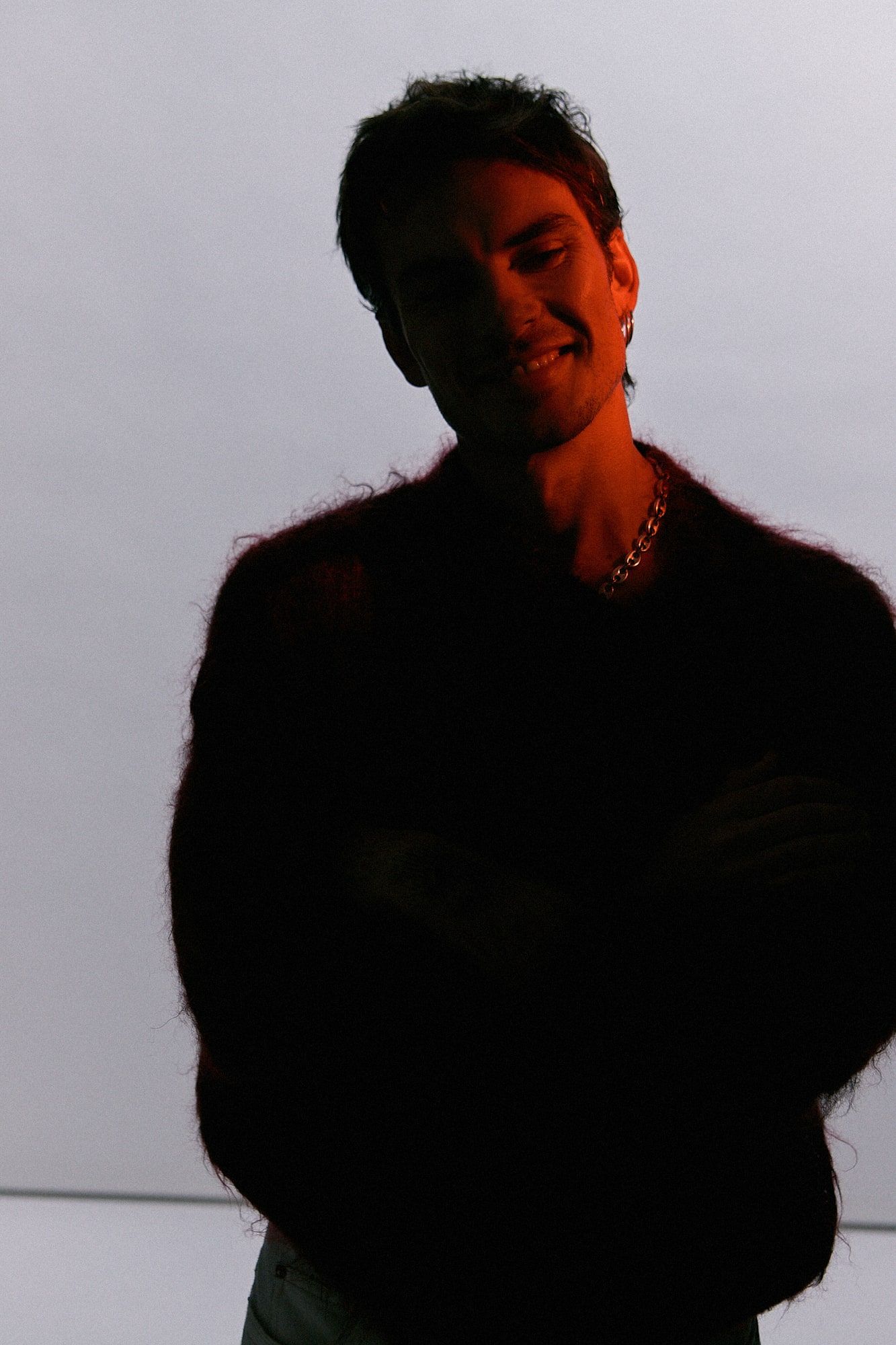 Andrés Koi sonriendo bajo una luz roja lateral