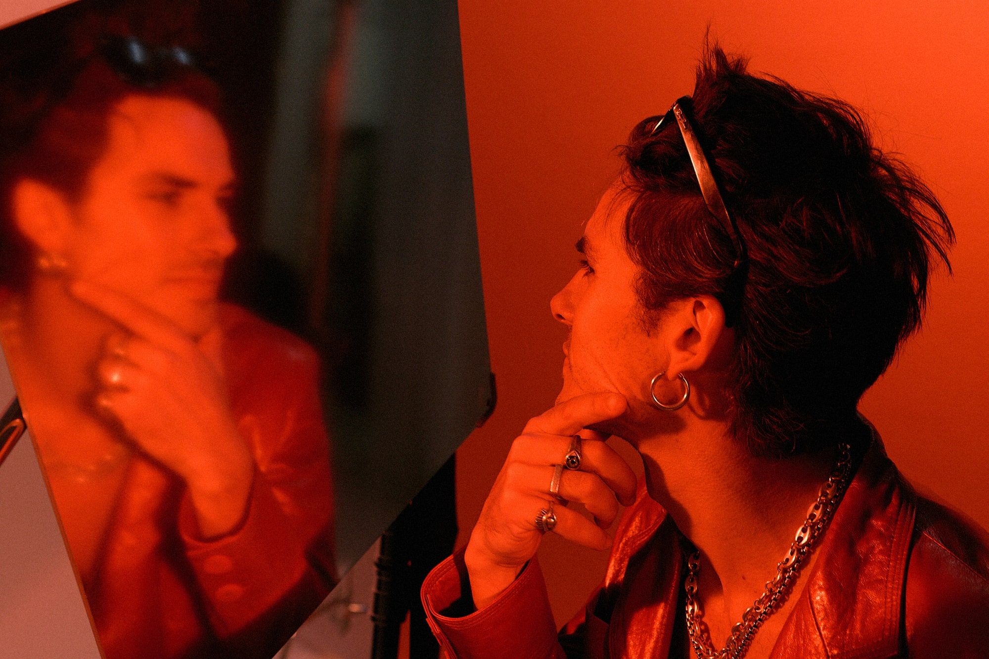 Andrés Koi de perfil frente a su reflejo bajo luz roja